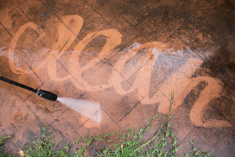 Cleaning backyard with pressure washer. Spring clean up