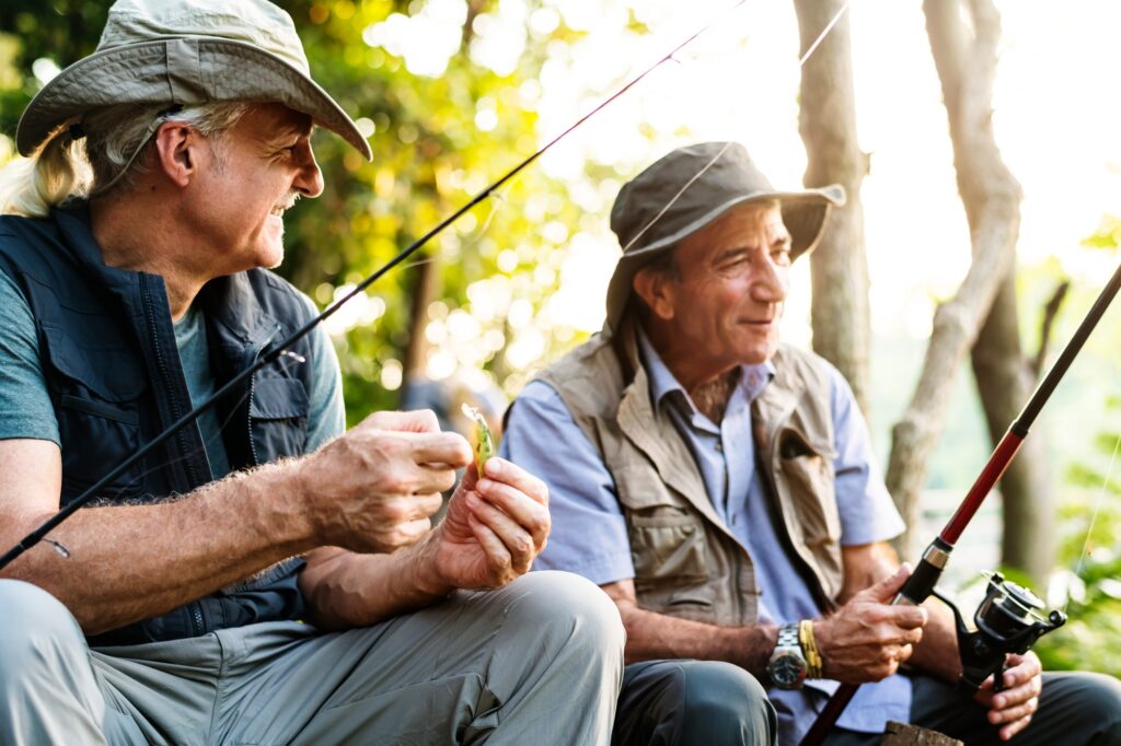 Senior friends fishing by the lake